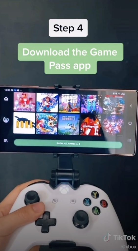 A screenshot of Xbox's TikTok video. A person is holding an Xbox remote with the TV in the background. It reads "Step 4: Download the Game Pass app"