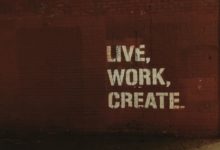 A brick wall with "live, work, create" painted on it