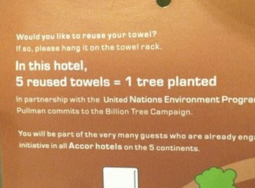 A hotel sign that says 5 reused towels = 1 tree planted via a partnership between United Nations Environment Program and Accor Hotels