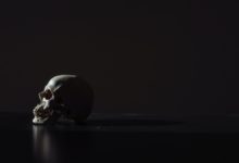 A minimalist image of a skull with a dark, black background